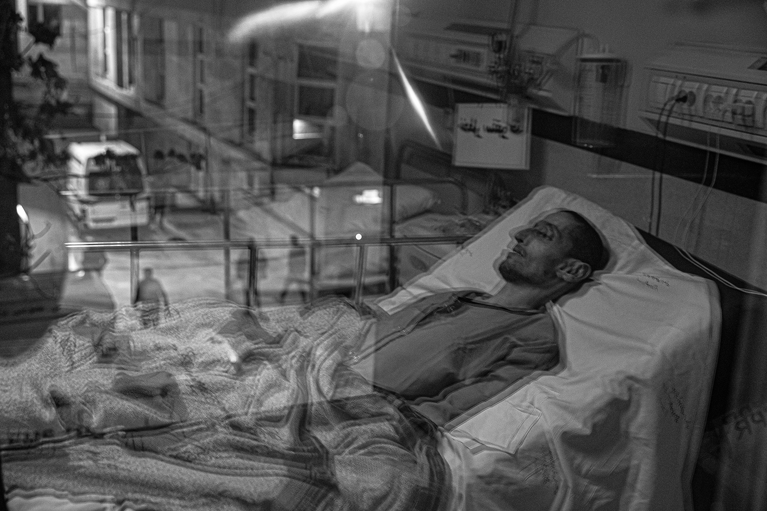 8 - Shafi, 30 years old, lays paralyzed in bed in hospital, after having been shot by Iran.jpg